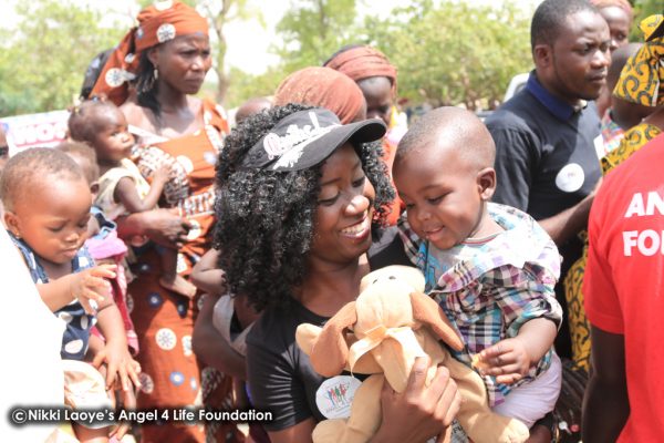 Nikki-Laoye-&-a-cute-baby-all-smiles-as-he-gets-a-toy (1)